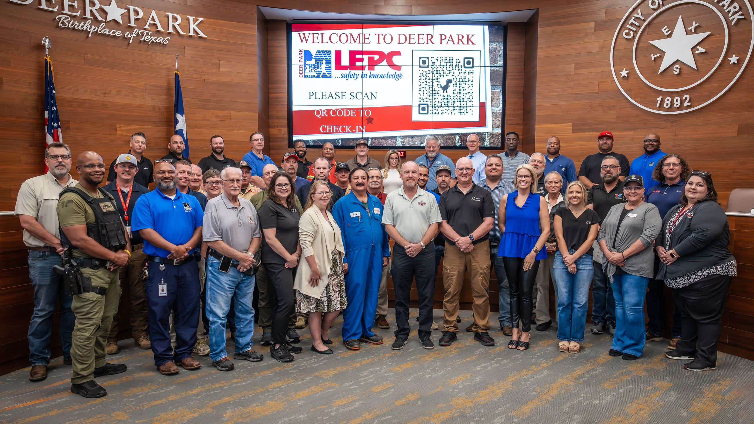 Group of men and women standing in several rows.